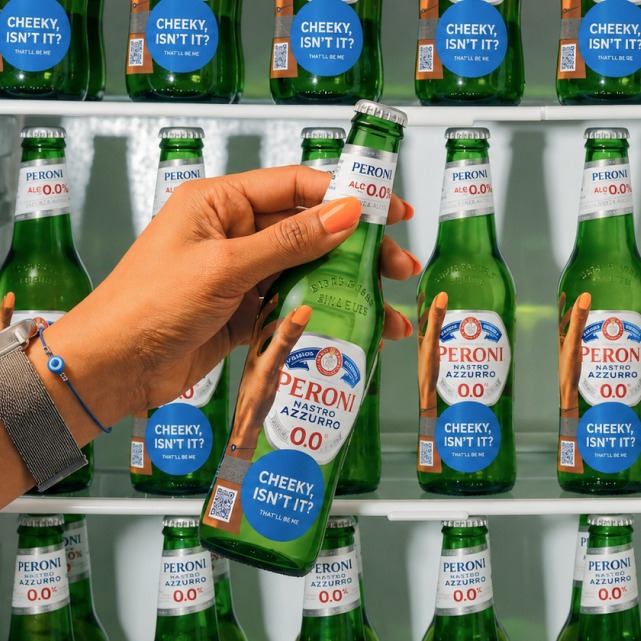 A hand taking a stickered Peroni from a fridge full of them